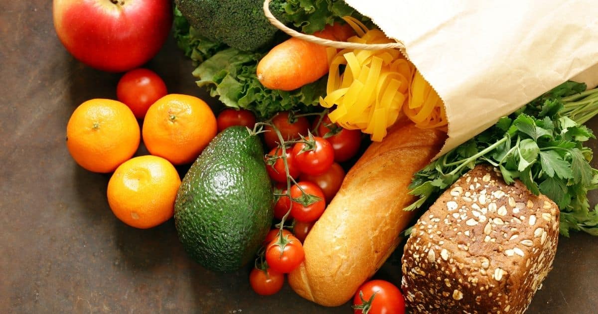 A bag of groceries laying on a table.