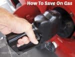 male hand putting gas in red car with a gas pump.