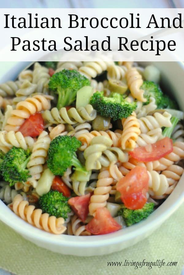 white bowl on a green background filled with tri color pasta mixed with broccoli, tomatoes, and peppers.  There is a text overlay that says italian broccoli and pasta salad recipe.