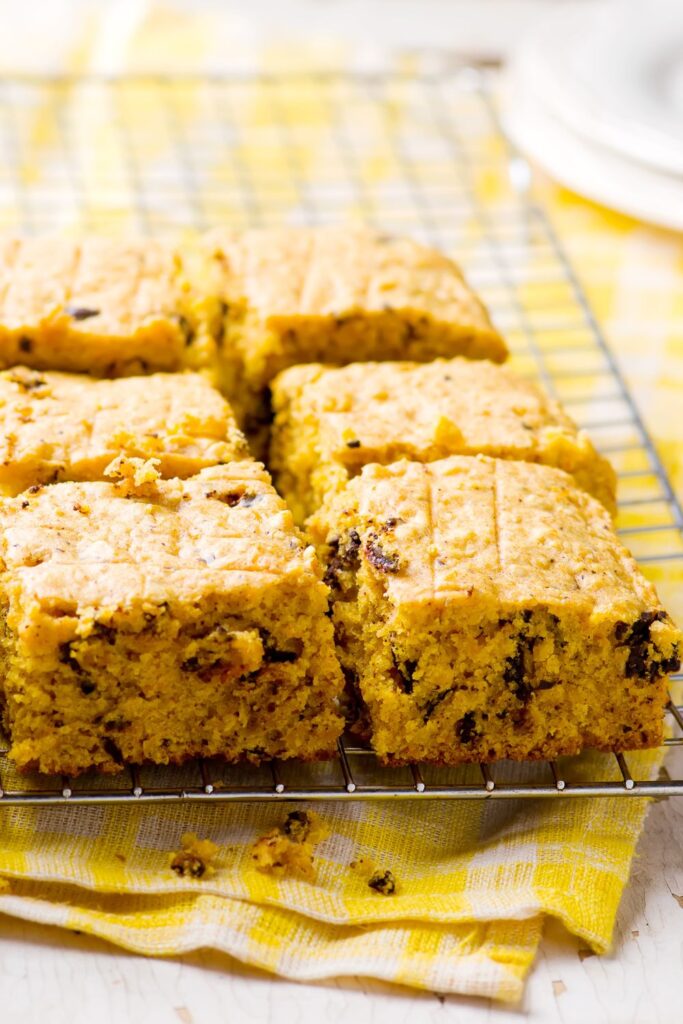 Pieces of the simple pumpkin bars on a cooling rack set on top of a yellow dishtowel.