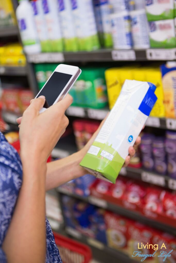 A woman comparing prices on items at the grocery store.