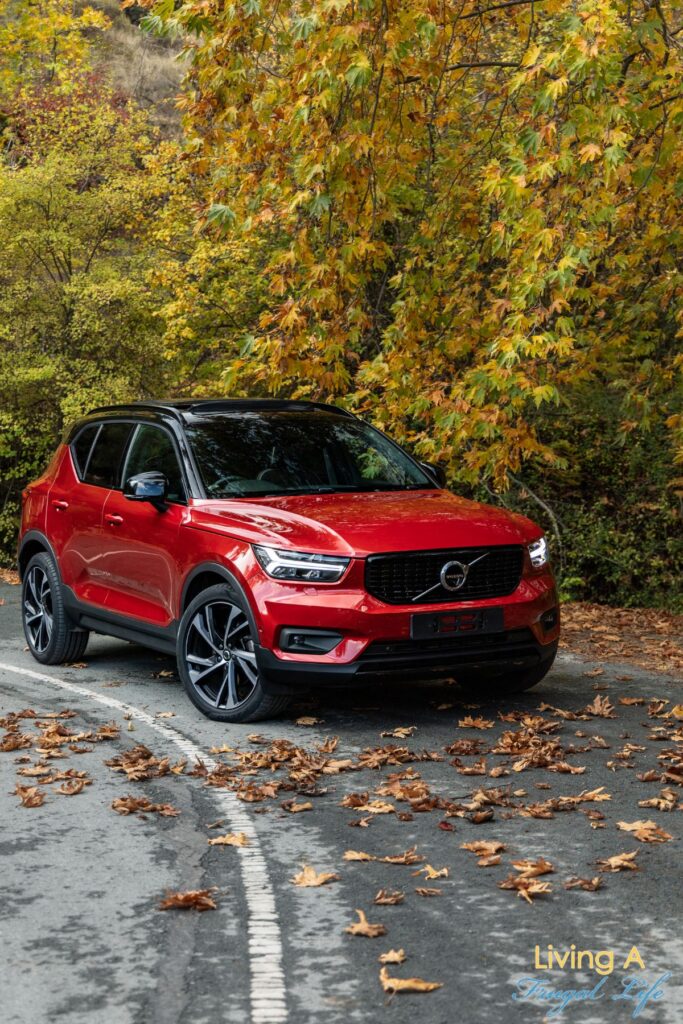 A red SUV driving in the woods.