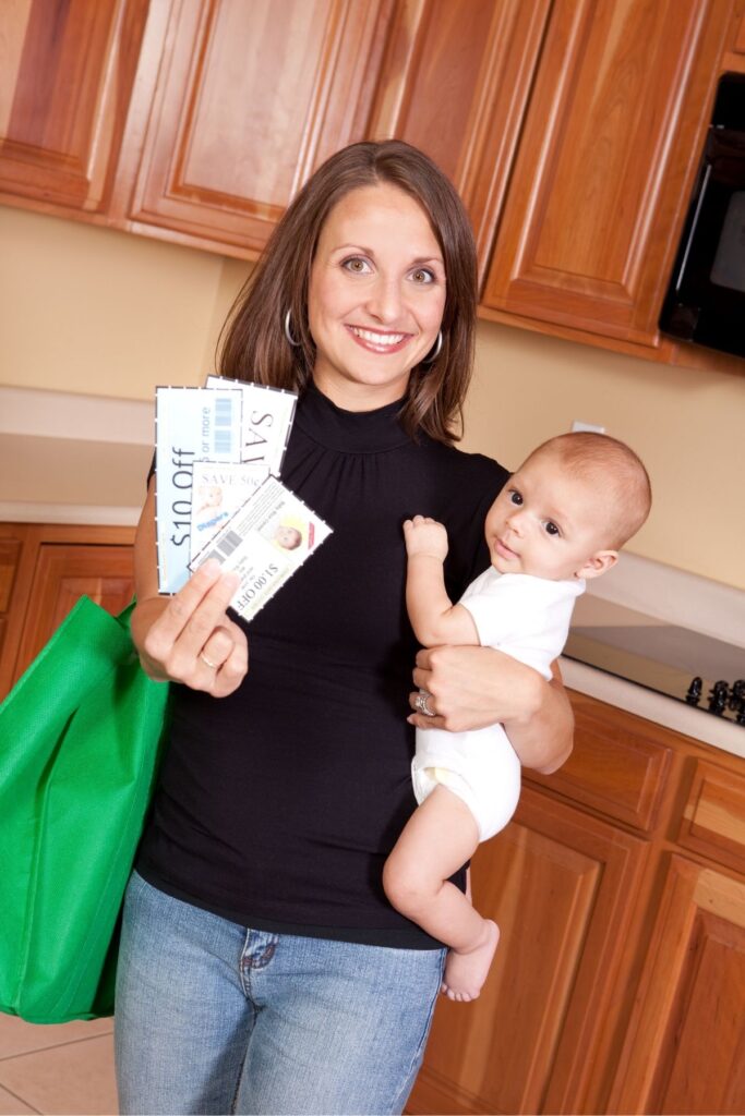Woman holding a baby and coupons.
