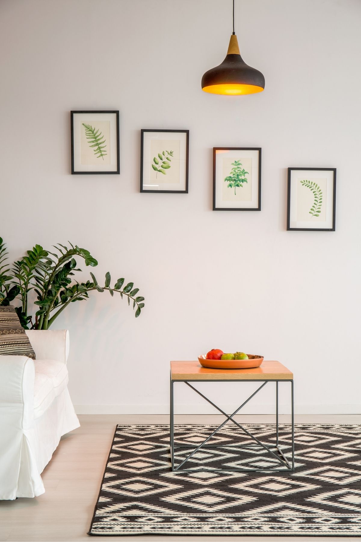 a minimalist living room with 4 pictures on the wall and a couch and table.